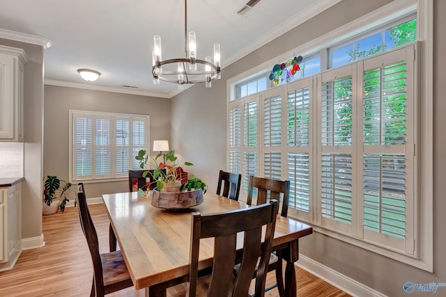 dining room featuring an inviting chandelier, ornamental molding, light wood finished floors, and baseboards