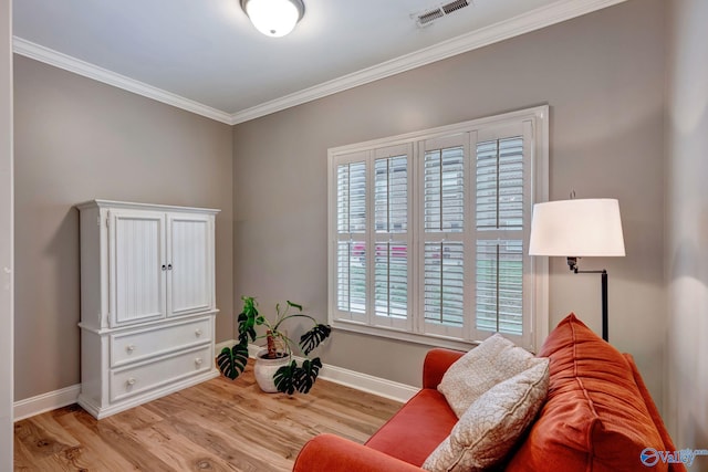 sitting room featuring crown molding, visible vents, light wood-style flooring, and baseboards