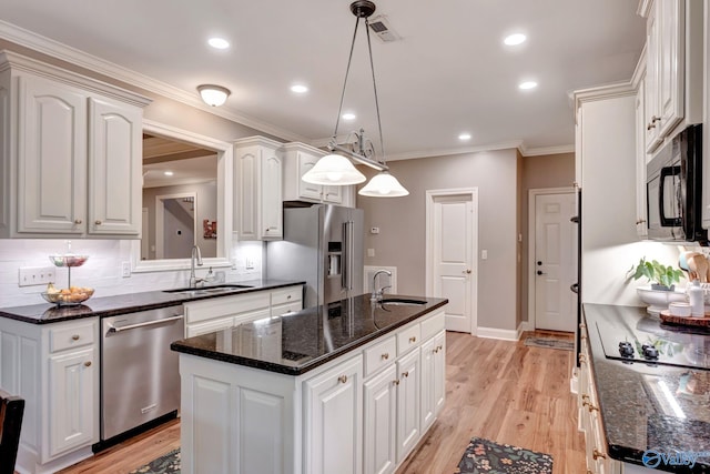 kitchen featuring visible vents, black appliances, an island with sink, and a sink