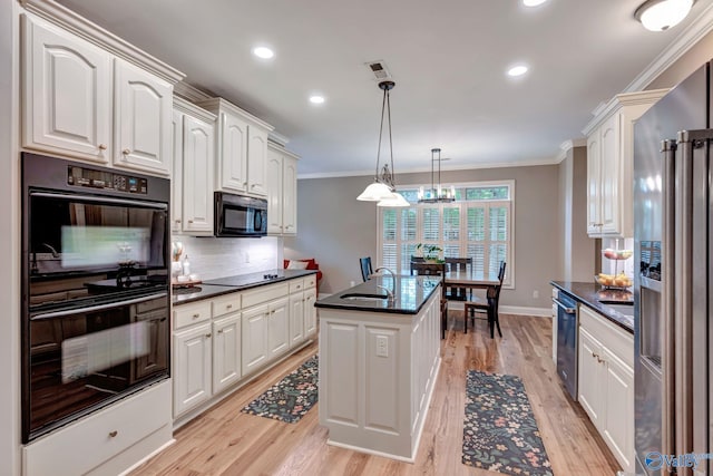 kitchen with white cabinets, black appliances, backsplash, ornamental molding, and a sink