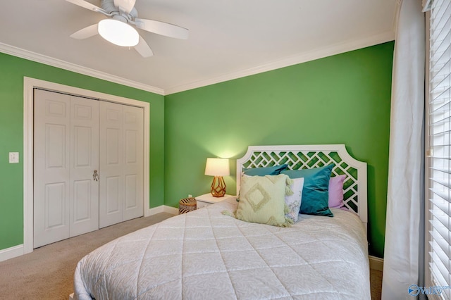 carpeted bedroom with a closet, crown molding, a ceiling fan, and baseboards