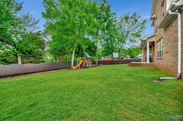 view of yard with a playground and a fenced backyard