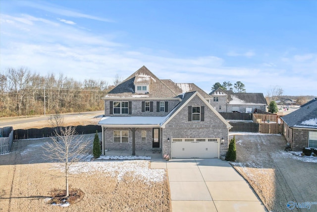 view of front facade with driveway, a garage, covered porch, fence, and brick siding