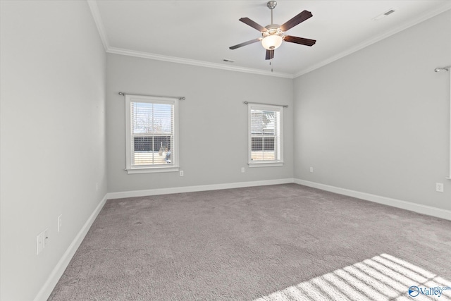 carpeted empty room featuring ornamental molding, a healthy amount of sunlight, visible vents, and baseboards