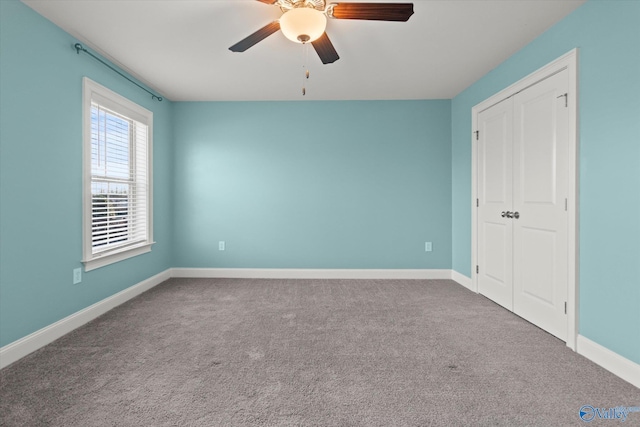 unfurnished bedroom featuring carpet floors, ceiling fan, baseboards, and a closet