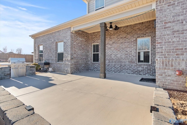 view of patio / terrace with exterior kitchen, area for grilling, and fence