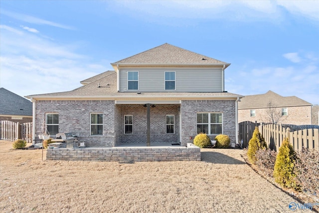 back of house featuring a shingled roof, fence, a patio, and brick siding