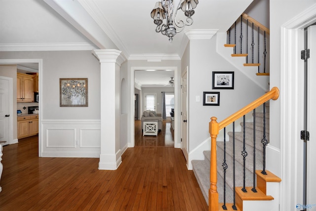 foyer with hardwood / wood-style floors, a ceiling fan, ornamental molding, and stairs