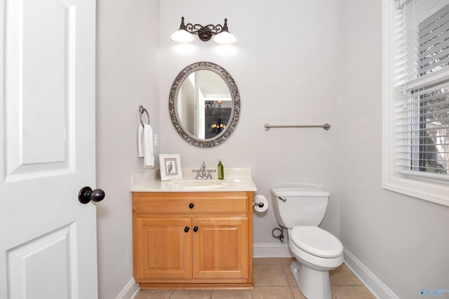 half bath featuring tile patterned flooring, vanity, toilet, and baseboards