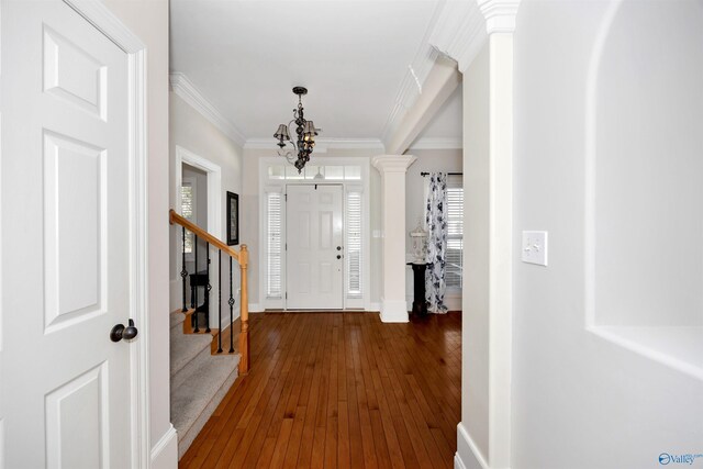 foyer entrance featuring baseboards, crown molding, stairway, and hardwood / wood-style floors