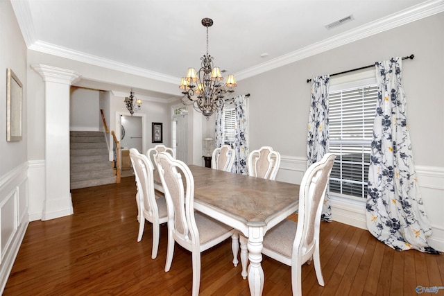 dining space featuring an inviting chandelier, visible vents, stairway, and wood finished floors