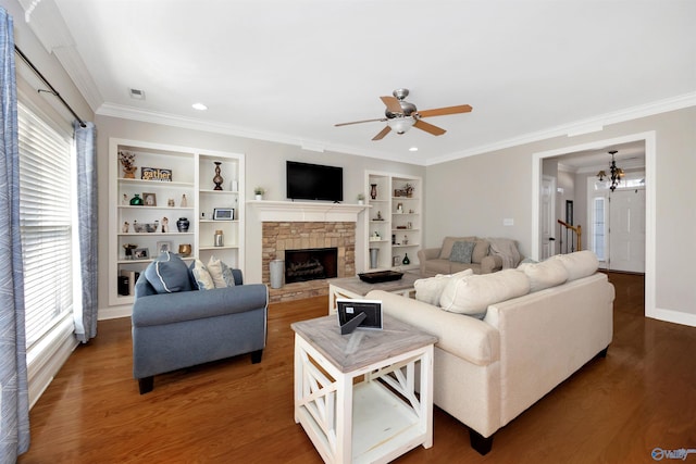 living room featuring a fireplace, ornamental molding, wood finished floors, and ceiling fan with notable chandelier