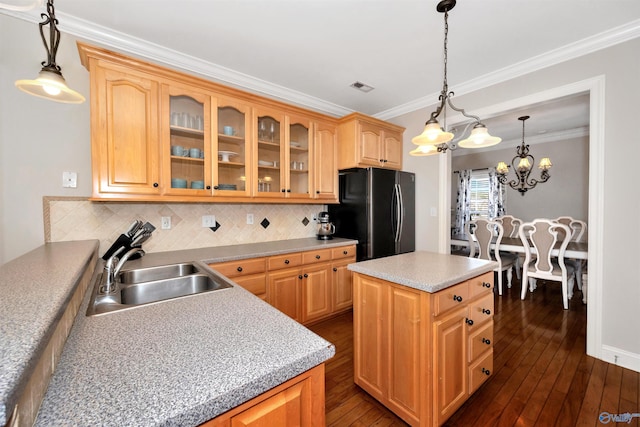 kitchen featuring a sink, freestanding refrigerator, visible vents, ornamental molding, and dark wood-style flooring