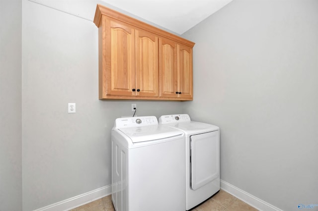 laundry room featuring baseboards, washing machine and clothes dryer, and cabinet space