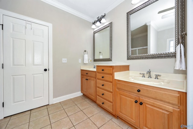 bathroom with crown molding, baseboards, double vanity, a sink, and tile patterned flooring