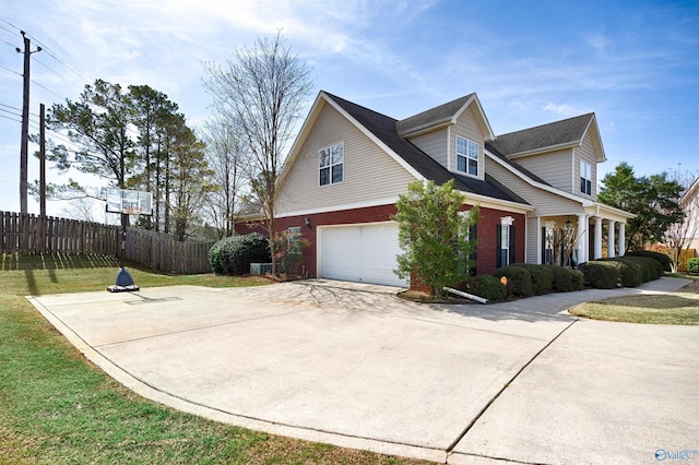 view of side of property featuring concrete driveway, fence, brick siding, a garage, and a lawn