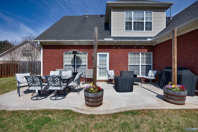 back of property with a patio, brick siding, fence, and a shingled roof