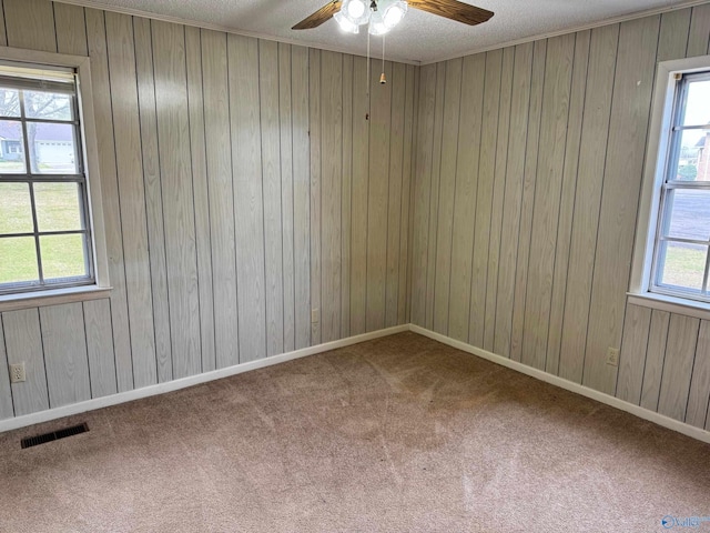 empty room with visible vents, a healthy amount of sunlight, and carpet