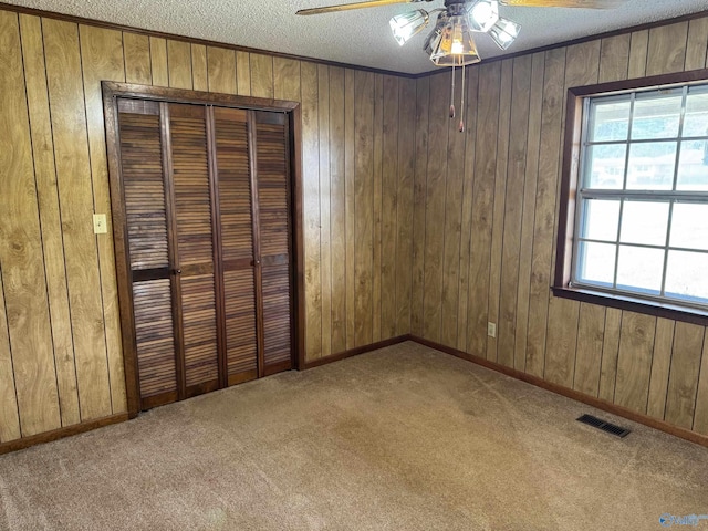 unfurnished bedroom with a closet, a textured ceiling, visible vents, and carpet