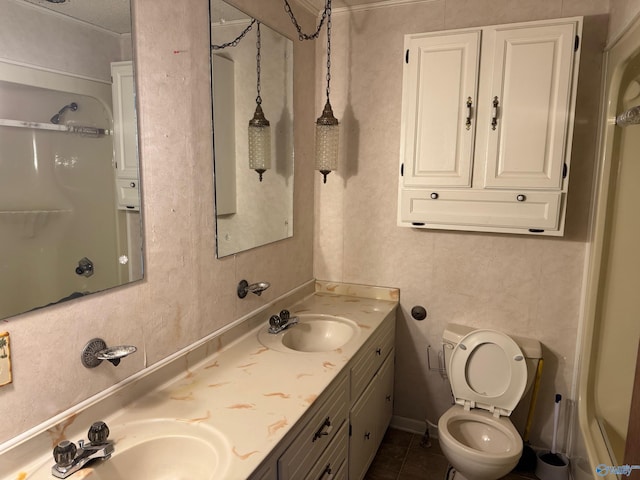 bathroom with double vanity, toilet, a sink, and walk in shower