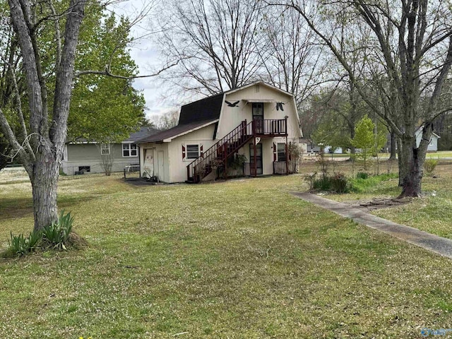 view of front facade featuring a front lawn, a gambrel roof, and stairway