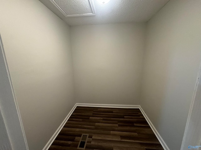 empty room with dark hardwood / wood-style flooring and a textured ceiling