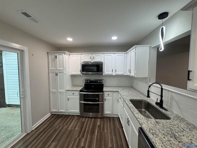 kitchen featuring stainless steel appliances, dark hardwood / wood-style flooring, sink, hanging light fixtures, and white cabinets