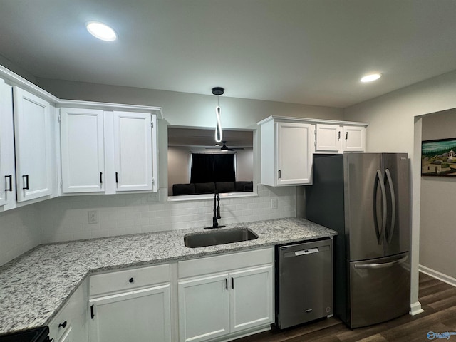 kitchen with white cabinets, stainless steel appliances, sink, dark hardwood / wood-style floors, and decorative backsplash