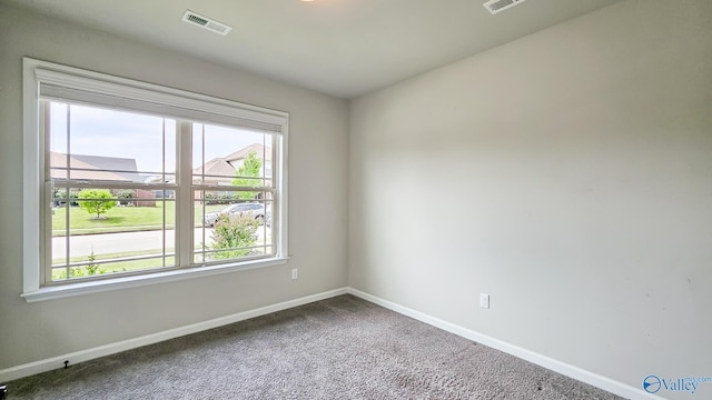 unfurnished room with carpet flooring, baseboards, and visible vents