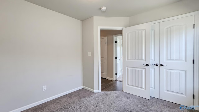 unfurnished bedroom featuring carpet floors, baseboards, and a closet