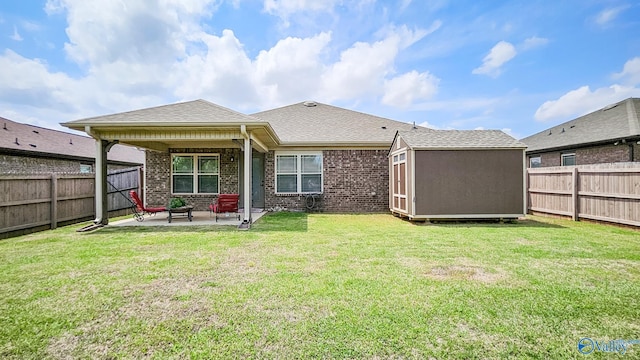 back of property featuring a lawn, brick siding, a fenced backyard, and a patio area