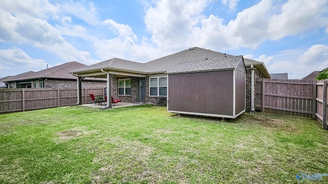 back of property with a patio, a fenced backyard, a yard, and a shingled roof