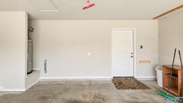 garage featuring baseboards and water heater