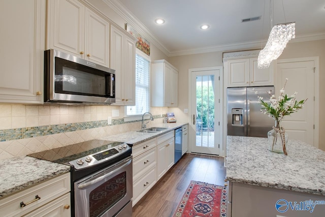 kitchen featuring pendant lighting, sink, stainless steel appliances, ornamental molding, and white cabinets