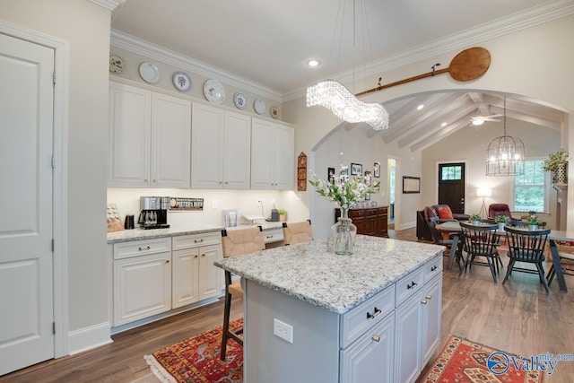 kitchen featuring hanging light fixtures, dark hardwood / wood-style floors, a center island, a notable chandelier, and white cabinets