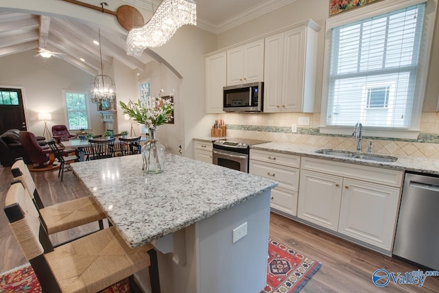 kitchen with sink, a breakfast bar area, white cabinets, and appliances with stainless steel finishes