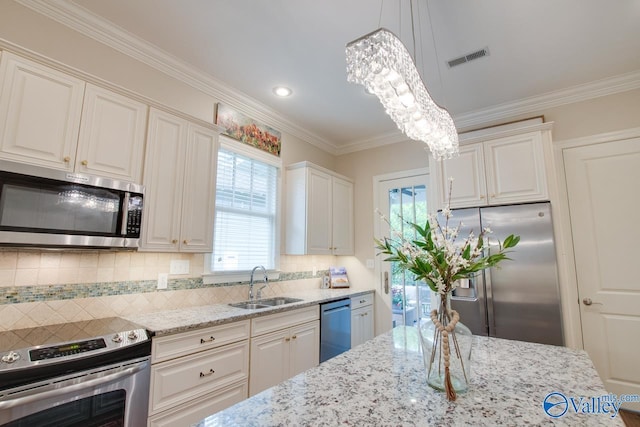 kitchen featuring white cabinetry, sink, stainless steel appliances, and hanging light fixtures