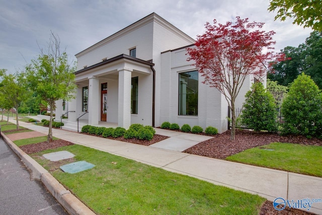 view of front of house with covered porch and a front yard