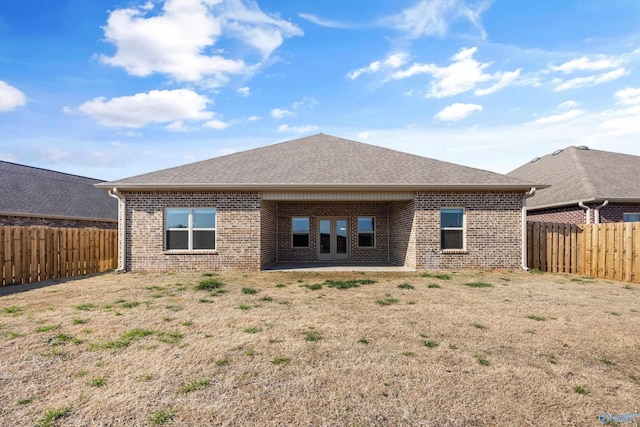 back of house featuring a patio area, a fenced backyard, brick siding, and a shingled roof