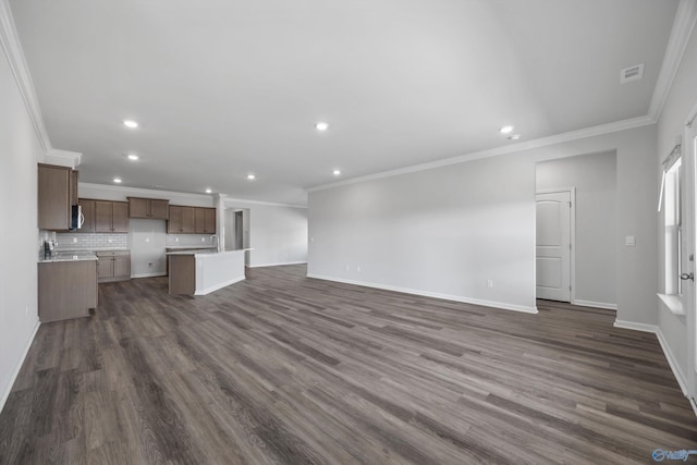 unfurnished living room with dark wood-type flooring, baseboards, and ornamental molding