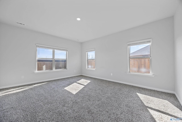 spare room featuring carpet, baseboards, and visible vents