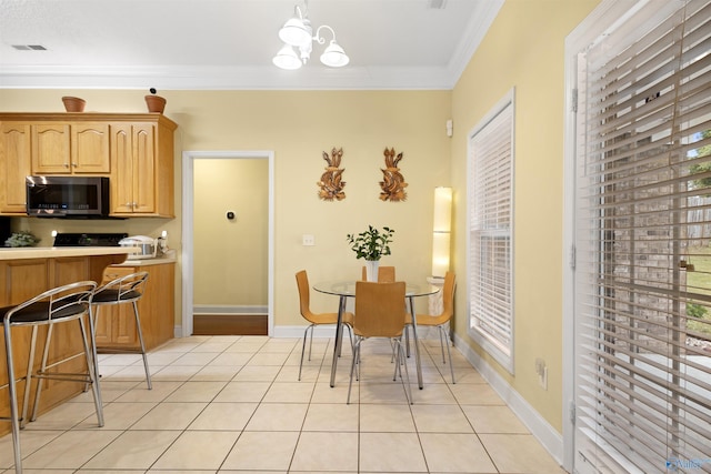663 Gooch Ln, Madison, AL 35758 - dining area with light tile patterned flooring, ornamental molding, a chandelier, and baseboards