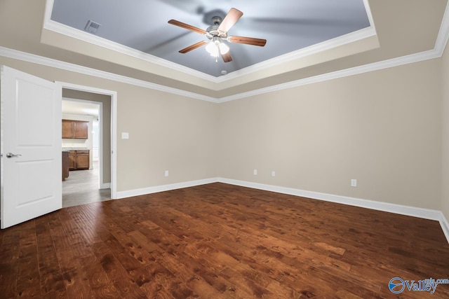 164 Moore Farm Cir NW, Huntsville, AL 35806 - empty room with visible vents, ornamental molding, ceiling fan, a tray ceiling, and dark wood finished floors