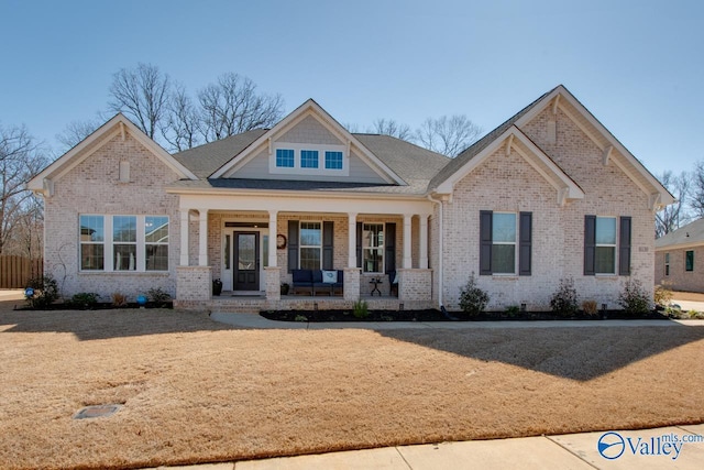 craftsman-style home featuring covered porch and brick siding