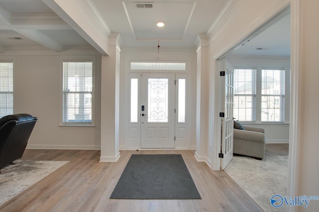 foyer featuring light wood-style flooring, visible vents, baseboards, ornamental molding, and beamed ceiling