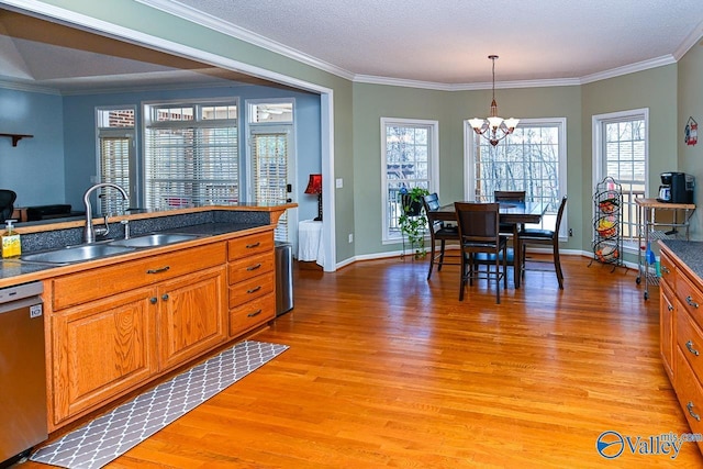 kitchen featuring dark countertops, light wood-style floors, brown cabinets, and stainless steel dishwasher