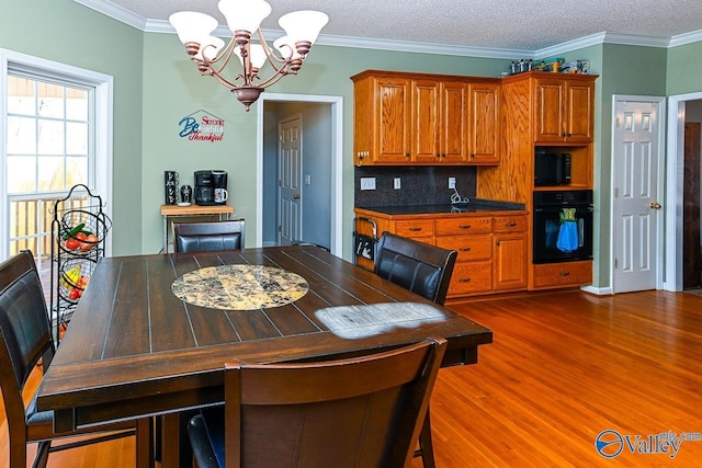 dining room with dark wood-style flooring, a notable chandelier, crown molding, and a textured ceiling