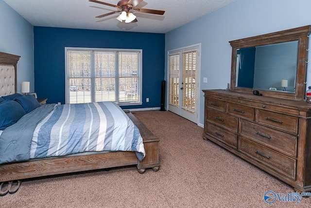 bedroom with ceiling fan, a textured ceiling, light colored carpet, baseboards, and access to exterior