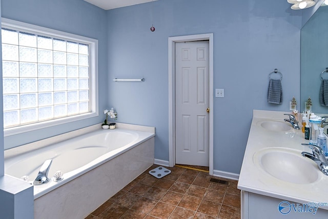 bathroom with visible vents, a sink, baseboards, and a bath