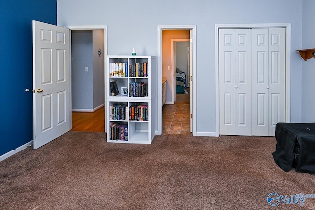 unfurnished bedroom featuring carpet floors, a closet, and baseboards